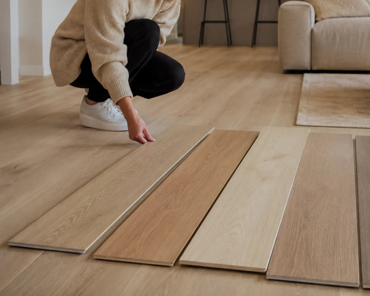 Vrouw met verschillende laminaat planken in haar woonkamer